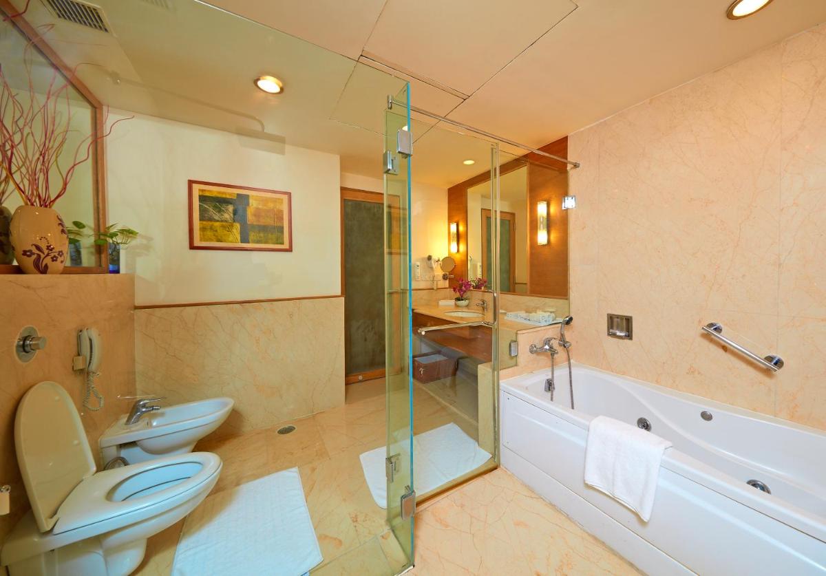 a bathroom with a toilet and a tub and a sink at Park Plaza Chennai OMR in Chennai
