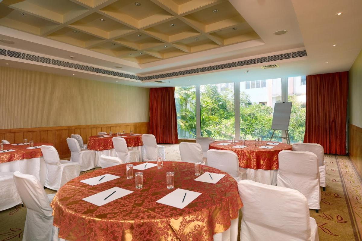 a banquet hall with tables and white chairs and a podium at Park Plaza Chennai OMR in Chennai