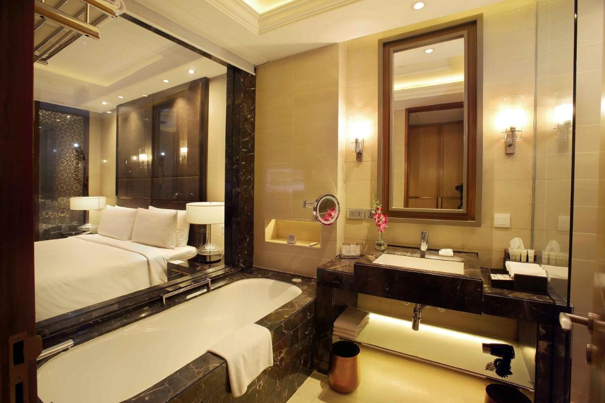 a bathroom with a bed and a bath tub and a sink at Crowne Plaza New Delhi Mayur Vihar Noida by IHG in New Delhi