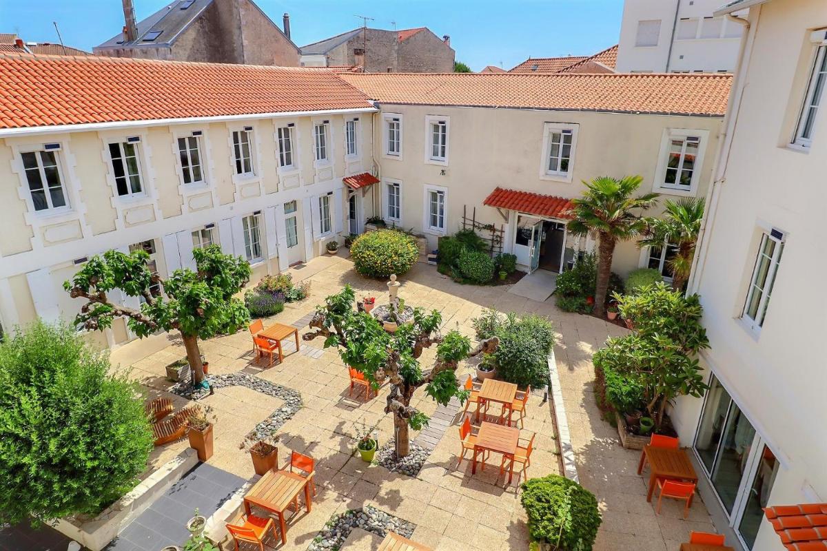 vue aérienne d'une cour avec des tables et des chaises dans l'établissement Grand Hôtel des Bains SPA, à Fouras