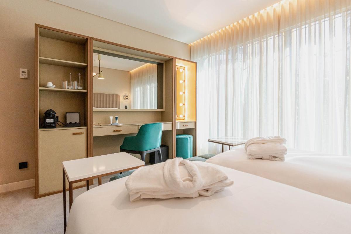 um quarto de hotel com duas camas, uma mesa e cadeiras em LUSTER Hotel em Lisboa mais 142 fotografias