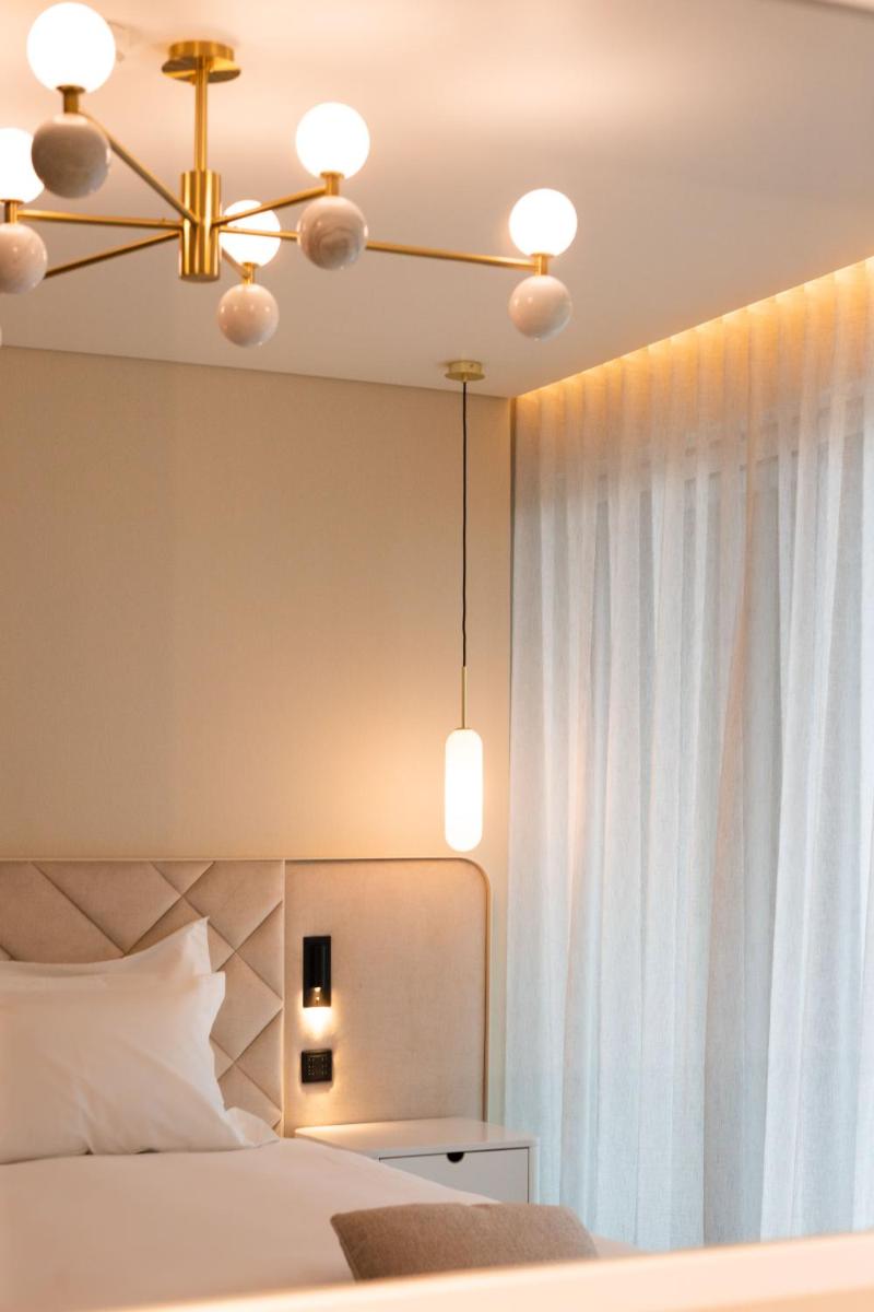 Uma cama ou camas num quarto em LUSTER Hotel