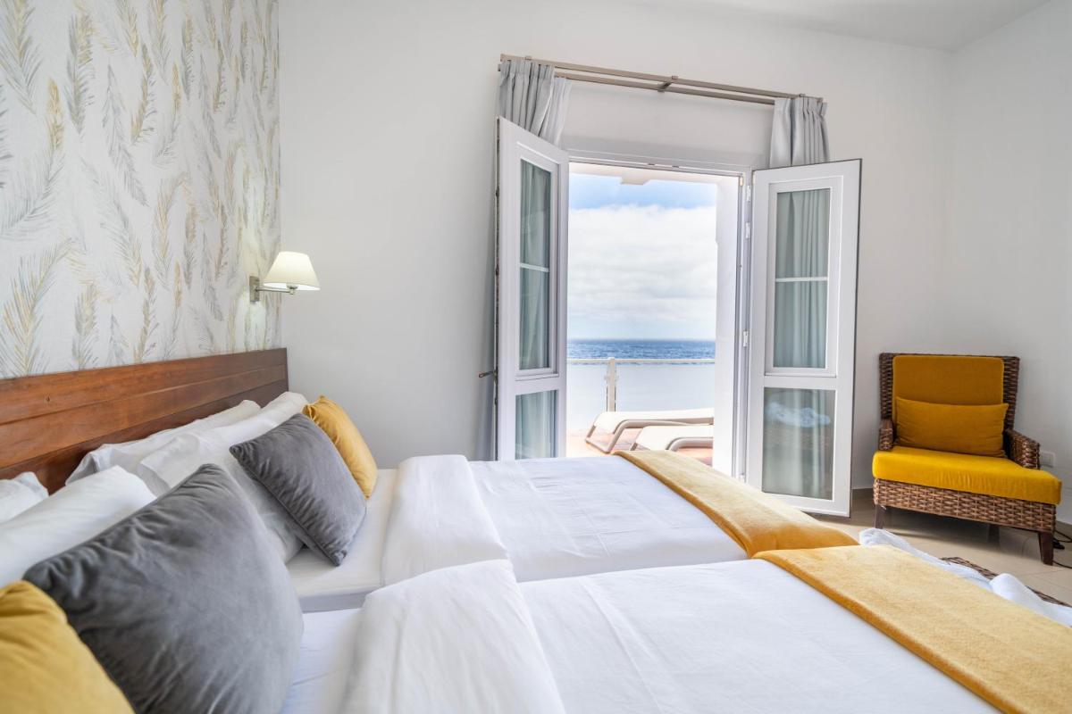 Un dormitorio con una cama grande y una ventana grande. en Balneario Pozo de la Salud, en Sabinosa