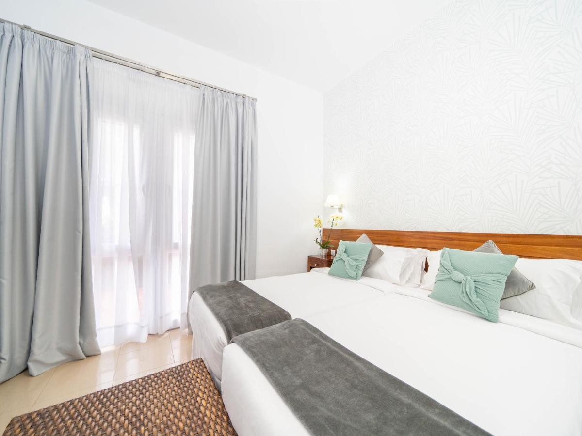 Un dormitorio con dos camas y una gran ventana. en Balneario Pozo de la Salud, en Sabinosa