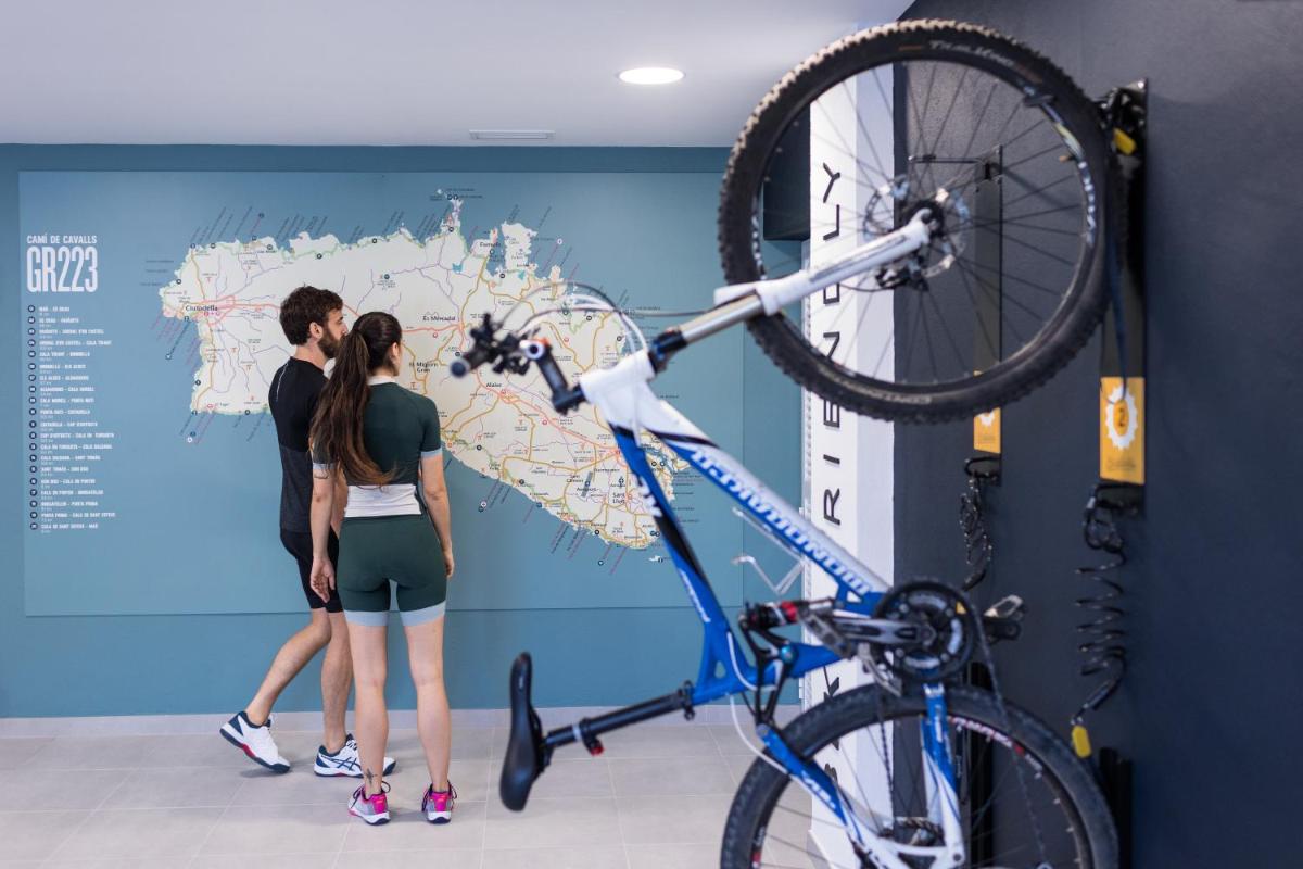 un hombre y una mujer mirando una bicicleta en una pared en Petit Sagitario Adults only, en Ciutadella 56 fotos más