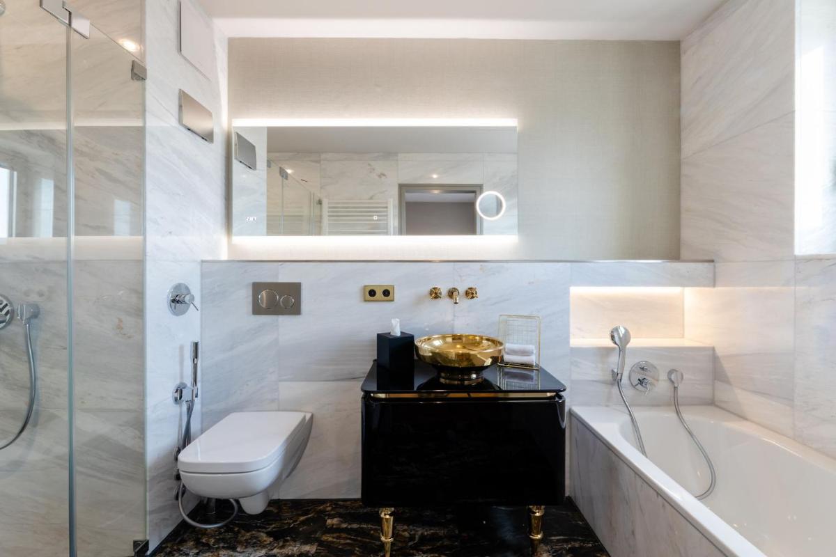 ein Badezimmer mit Badewanne, Toilette und Waschbecken in der Unterkunft Fourty Three Luxury Serviced Apartments in Düsseldorf + 37 Fotos