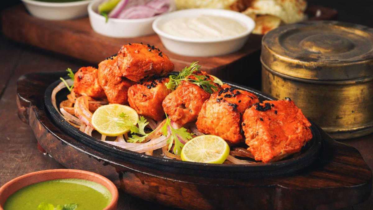 a bowl of food with shrimp and noodles and lime slices at InterContinental Marine Drive Mumbai by IHG in Mumbai