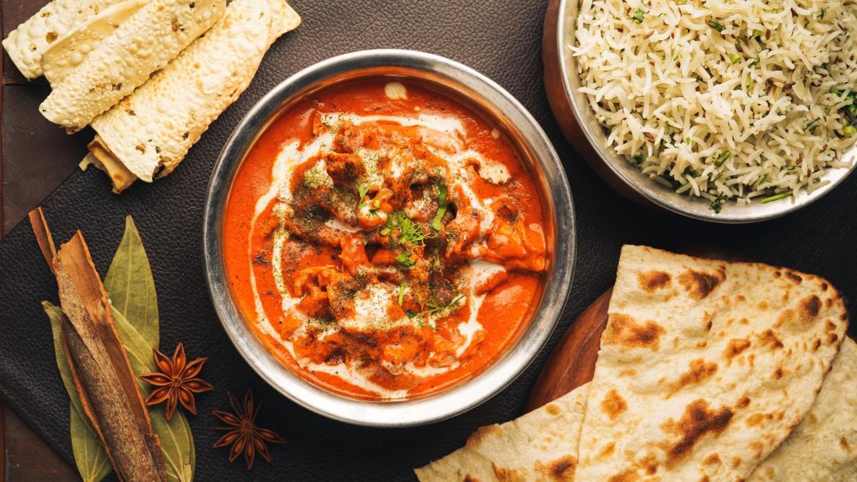 a table topped with a bowl of soup and rice at InterContinental Marine Drive Mumbai by IHG in Mumbai