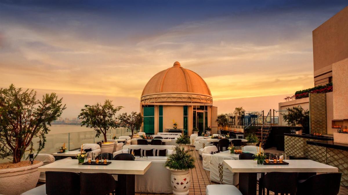a restaurant with white tables and a building at InterContinental Marine Drive Mumbai by IHG in Mumbai