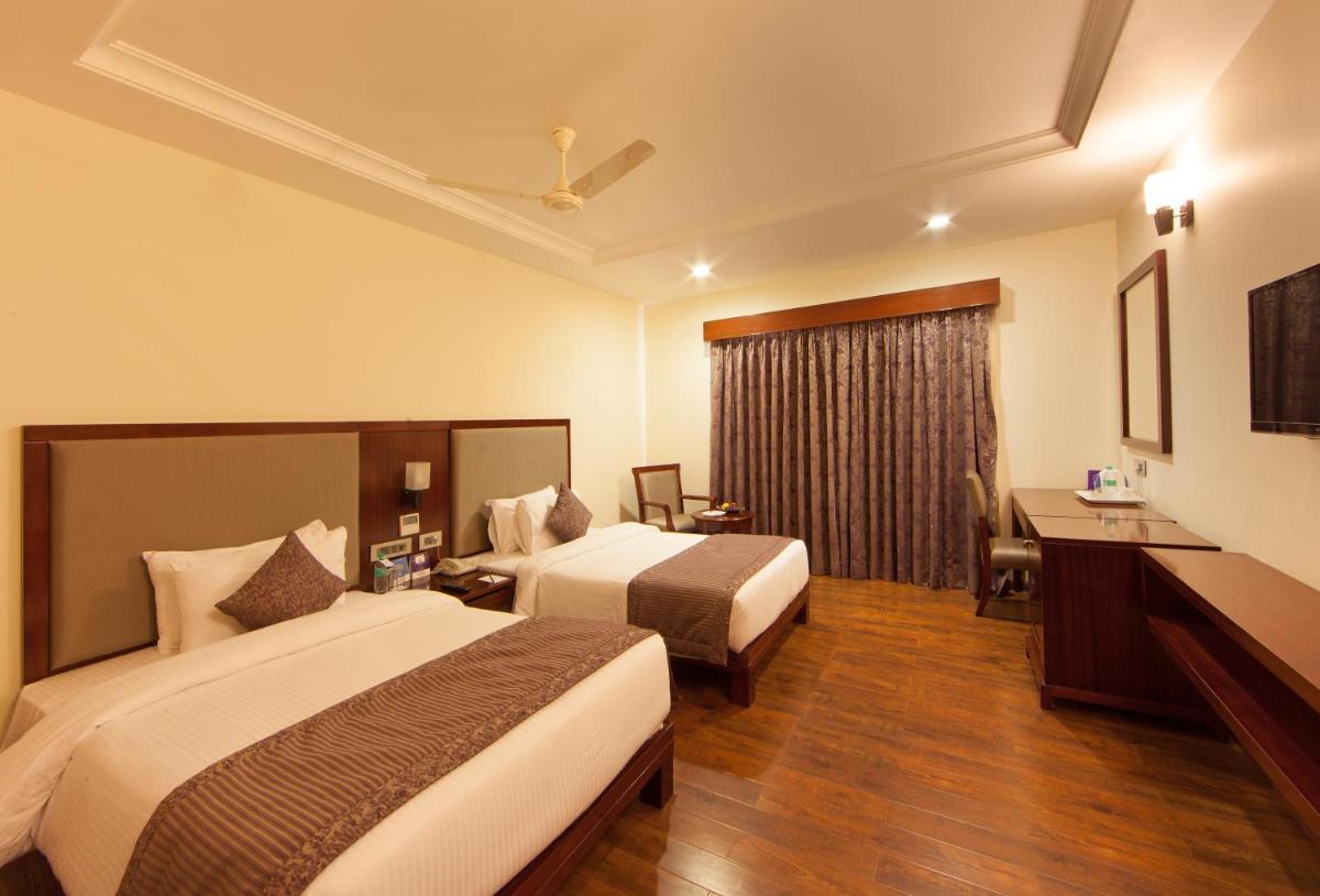 a hotel room with two beds and a desk at Fortune Select Grand Ridge, Tirupati - Member ITC Hotels' Group in Tirupati