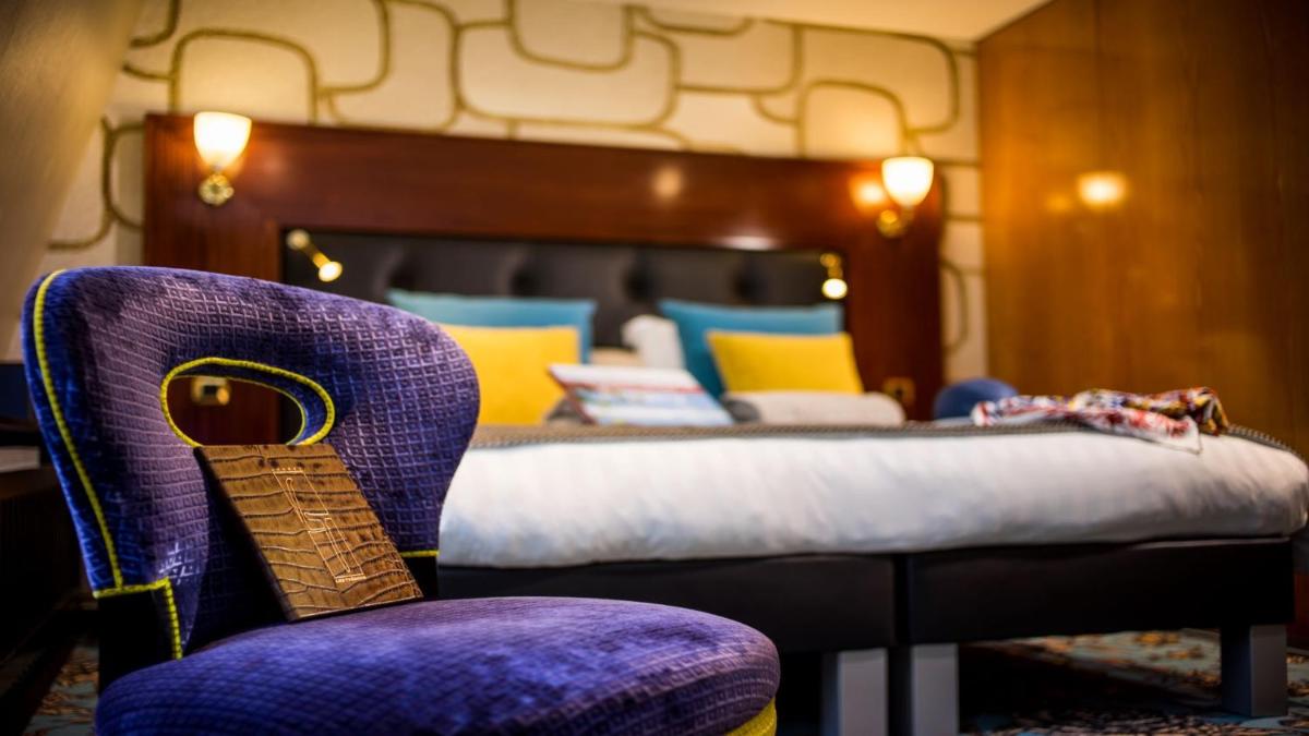 une chambre avec un lit et une chaise violette dans l'établissement Les Trésoms Lake and Spa Resort, à Annecy 63 autres photos