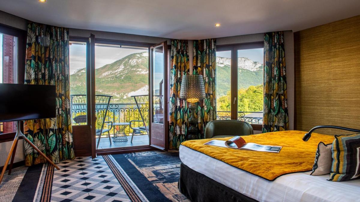 une chambre d'hôtel avec un lit et un balcon dans l'établissement Les Trésoms Lake and Spa Resort, à Annecy
