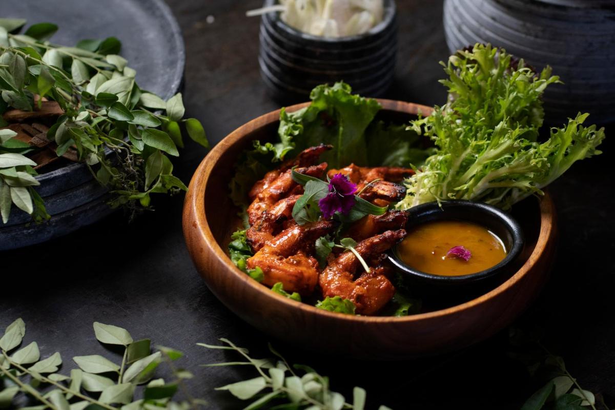 a bowl of food with a salad and a dipping sauce at Feathers- A Radha Hotel, Chennai in Chennai