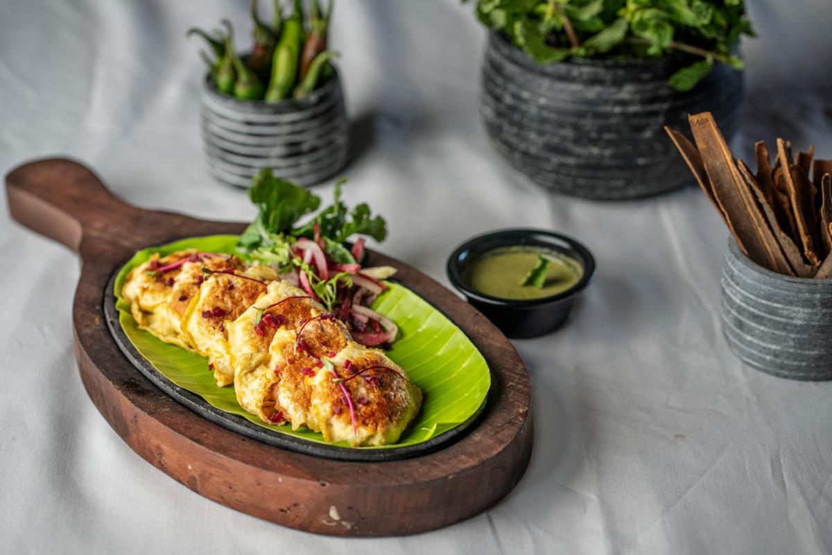 a plate of food on a table with a plate of food at Feathers- A Radha Hotel, Chennai in Chennai