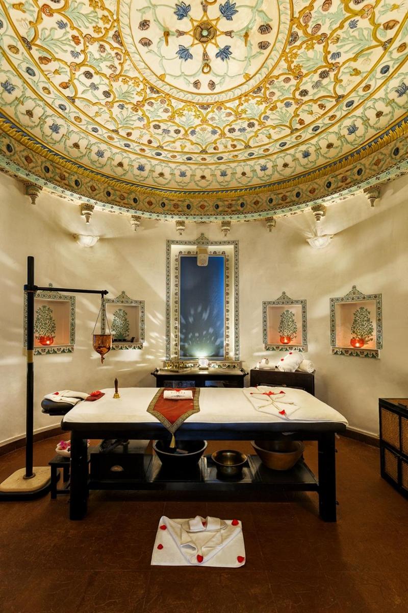 a room with a ceiling and a table with food at Shiv Niwas Palace by HRH Group of Hotels in Udaipur