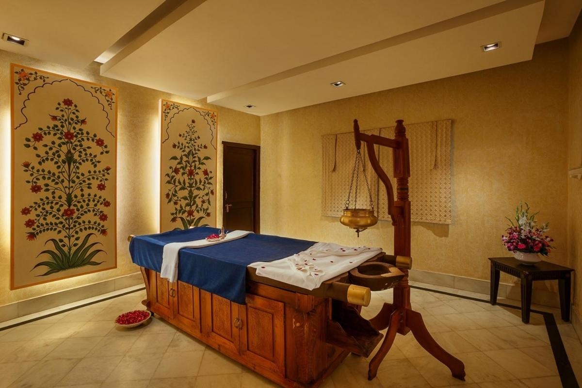 a room with a bed and paintings on the walls at Shiv Niwas Palace by HRH Group of Hotels in Udaipur