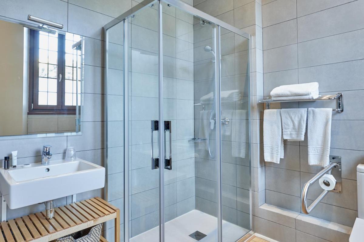 Un baño con ducha de cristal y lavabo. en Hotel Parada Puigcerda, en Puigcerdà 39 fotos más