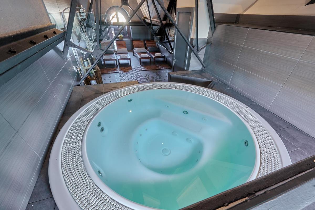 bañera grande en una habitación con escalera en Hotel Parada Puigcerda, en Puigcerdà