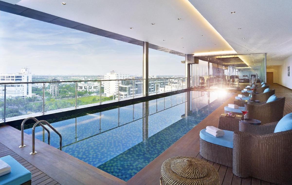 a swimming pool with a view of a building at Vivanta Kolkata EM Bypass in Kolkata