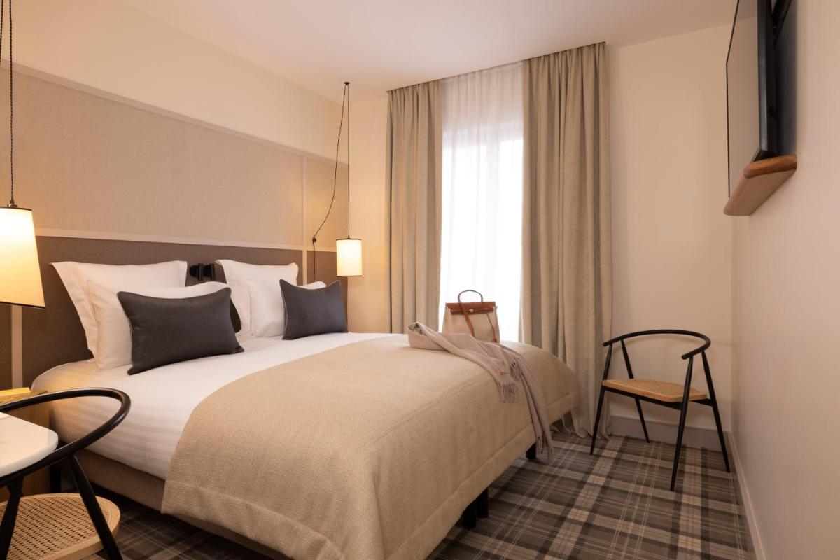 une chambre d'hôtel avec un grand lit et une fenêtre dans l'établissement Hôtel Toujours & Spa, à Paris