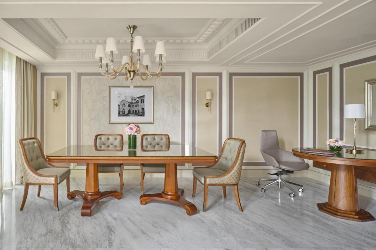a dining room with a table and chairs at The Fullerton Hotel Singapore in Singapore