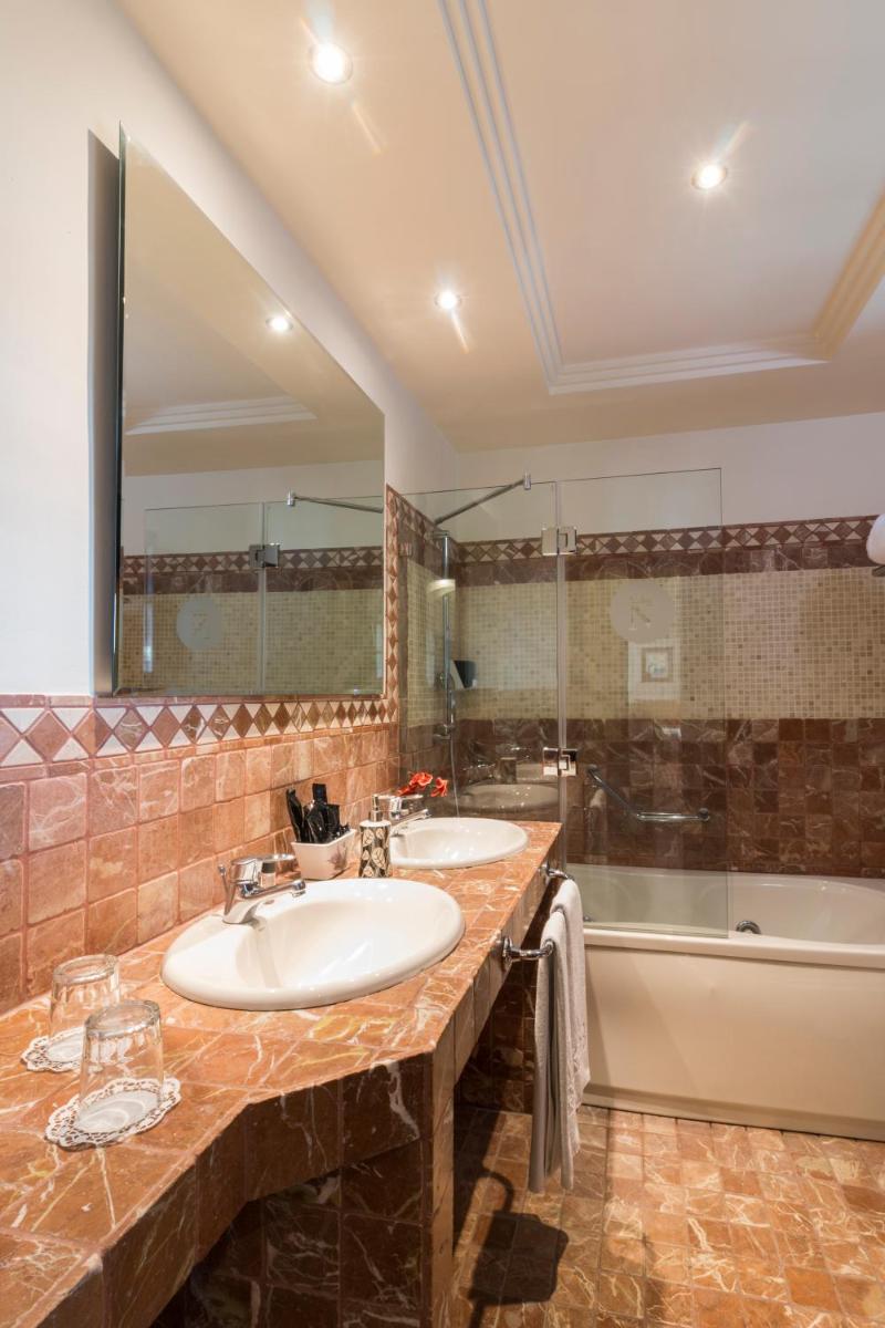 Un baño con dos lavabos y una bañera. en Laguna Nivaria Hotel & Spa, en La Laguna