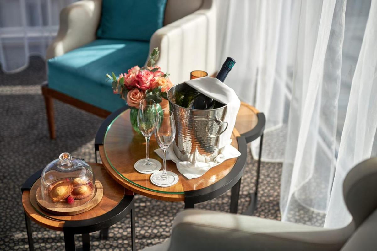 - une table basse avec un seau de vin et de fleurs dans l'établissement Maison Albar - Le Pont-Neuf, à Paris