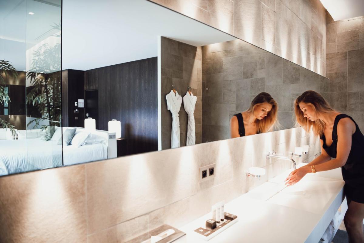 une femme se tient devant un miroir de salle de bains dans l'établissement Bdesign & Spa, à Paradou