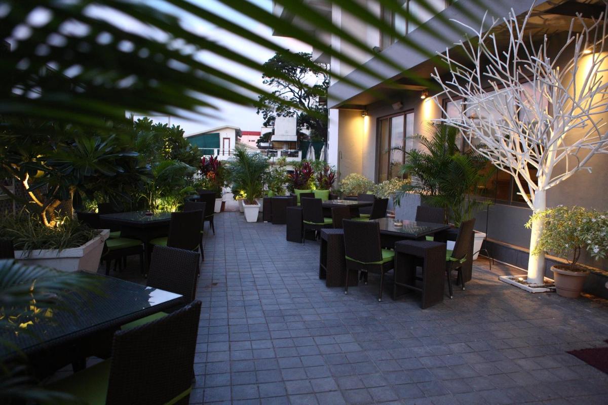 an outdoor patio with tables and chairs and plants at Radisson Blu Plaza Hotel Hyderabad Banjara Hills in Hyderabad an outdoor patio with tables and chairs and plants at Radisson Blu Plaza Hotel Hyderabad Banjara Hills in Hyderabad