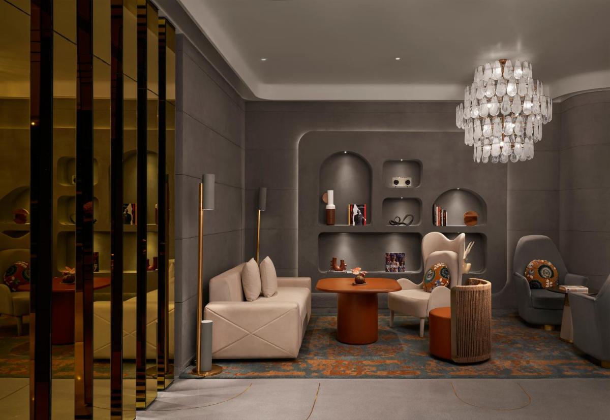 a living room with a chandelier and chairs and a table at Hyatt Centric Sector17 Chandigarh in Chandīgarh