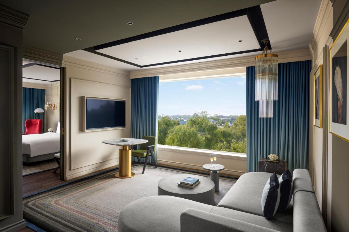 a living room with a couch and a large window at Hyatt Centric Sector17 Chandigarh in Chandīgarh