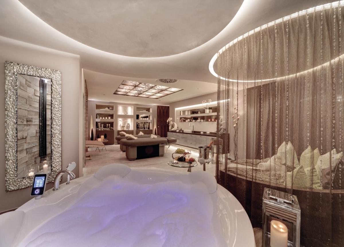 ein Bad mit einer großen Badewanne in einem Zimmer in der Unterkunft Wellness- & Sporthotel Jagdhof in Röhrnbach