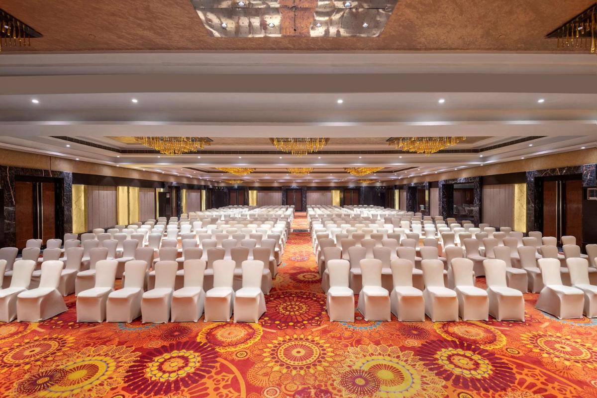 an empty banquet hall with white chairs in it at Radisson Blu Kaushambi Delhi NCR in Ghaziabad