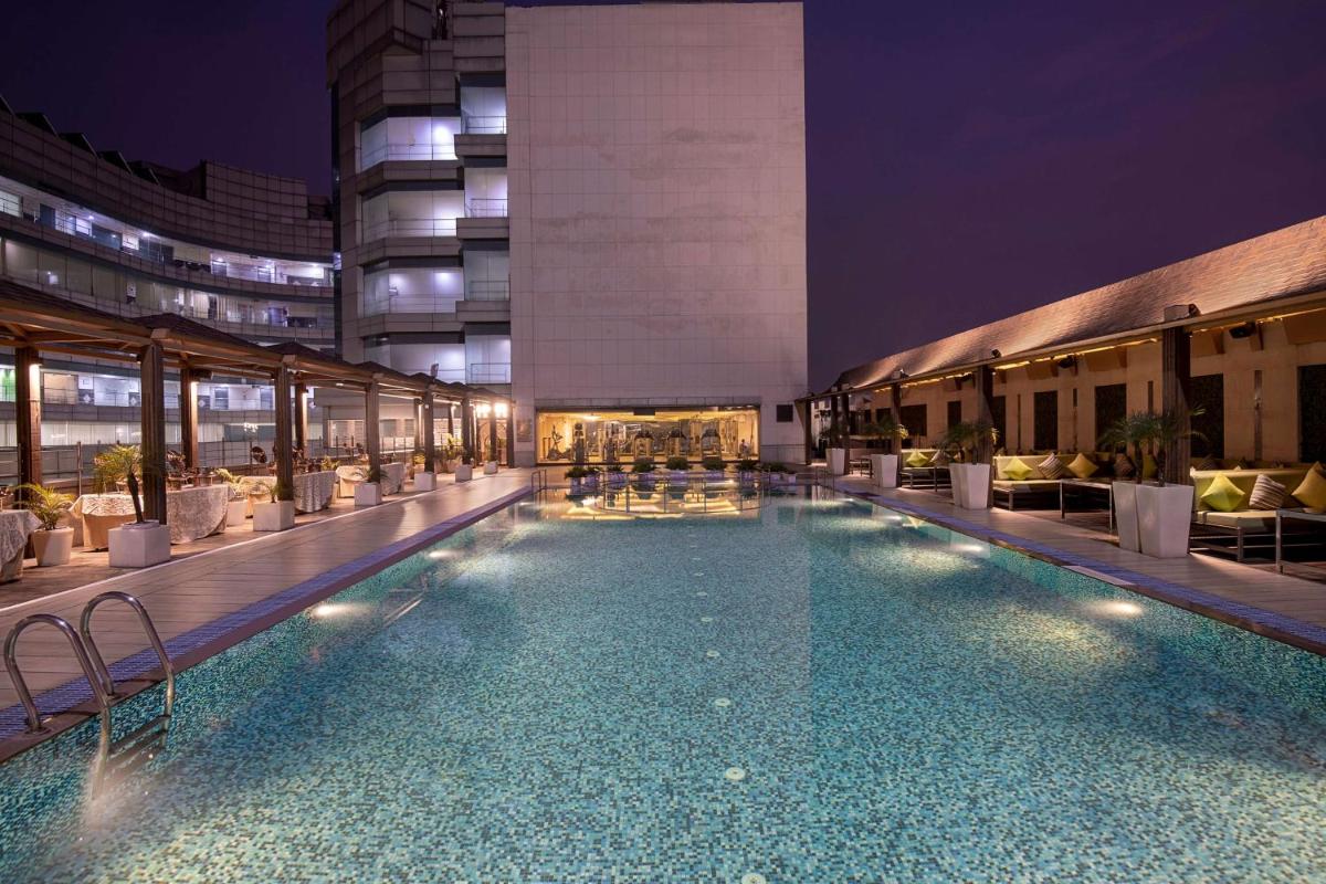 a large swimming pool in a building at night at Radisson Blu Kaushambi Delhi NCR in Ghaziabad