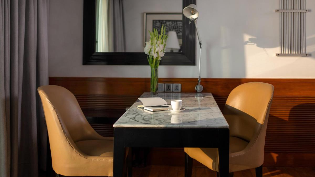a table with chairs and a vase of flowers on it at InterContinental Marine Drive Mumbai by IHG in Mumbai