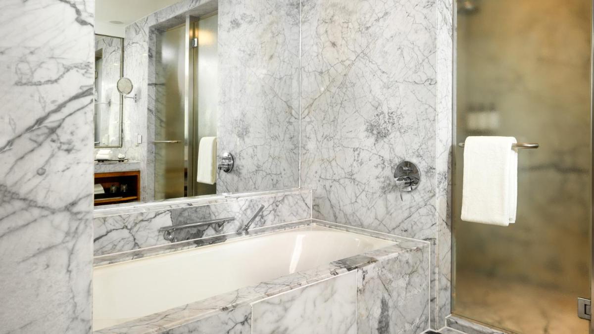 a bathroom with a bath tub and a mirror at InterContinental Marine Drive Mumbai by IHG in Mumbai