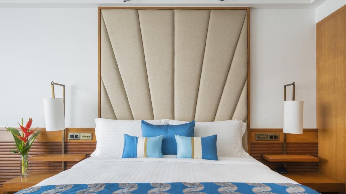 a bedroom with a large bed with blue pillows at InterContinental Marine Drive Mumbai by IHG in Mumbai