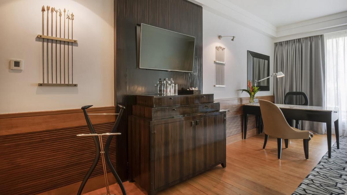 a hotel room with a desk and a television on a wall at InterContinental Marine Drive Mumbai by IHG in Mumbai
