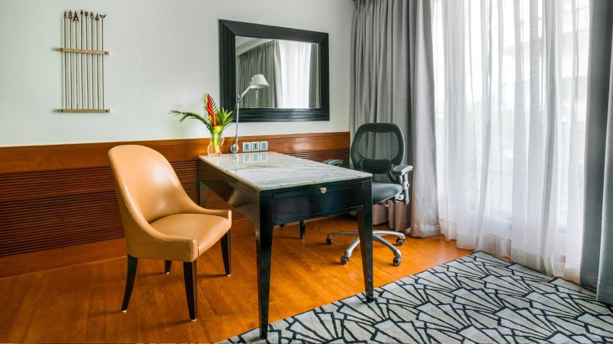 a room with a desk and two chairs and a mirror at InterContinental Marine Drive Mumbai by IHG in Mumbai