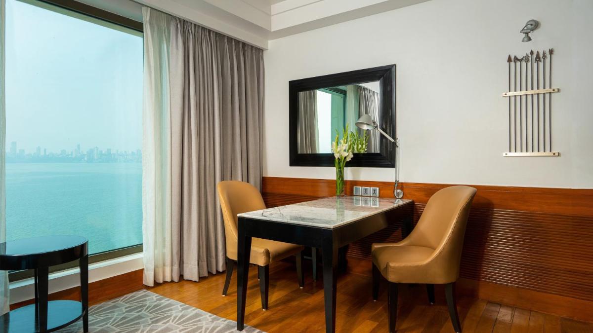 a dining room with a table and chairs and a large window at InterContinental Marine Drive Mumbai by IHG in Mumbai