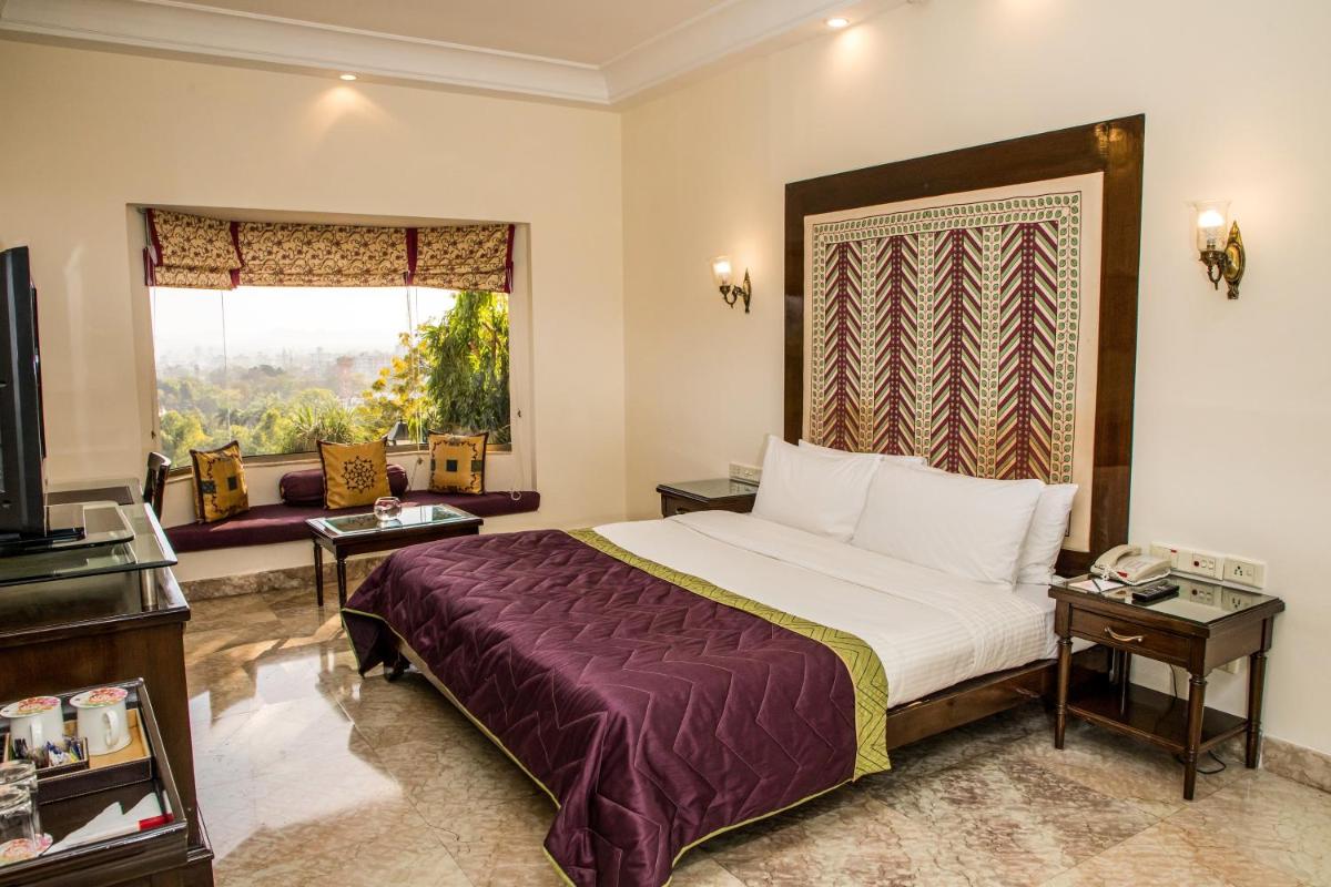 a hotel room with a bed and a window at The Lalit Laxmi Vilas Palace in Udaipur