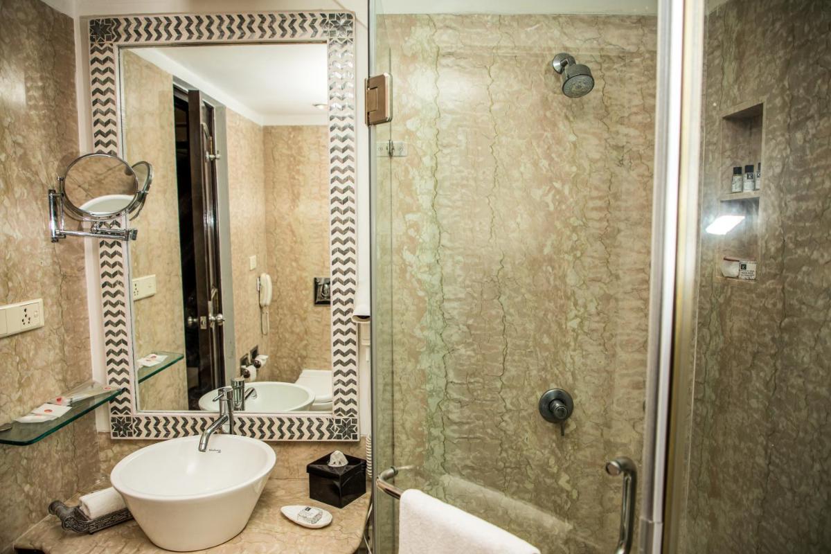 a bathroom with a sink and a shower at The Lalit Laxmi Vilas Palace in Udaipur
