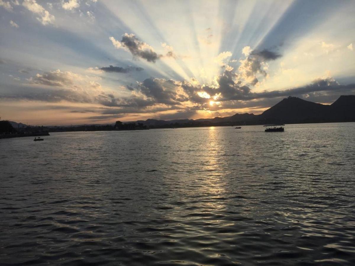 a sunset over a large body of water at The Lalit Laxmi Vilas Palace in Udaipur