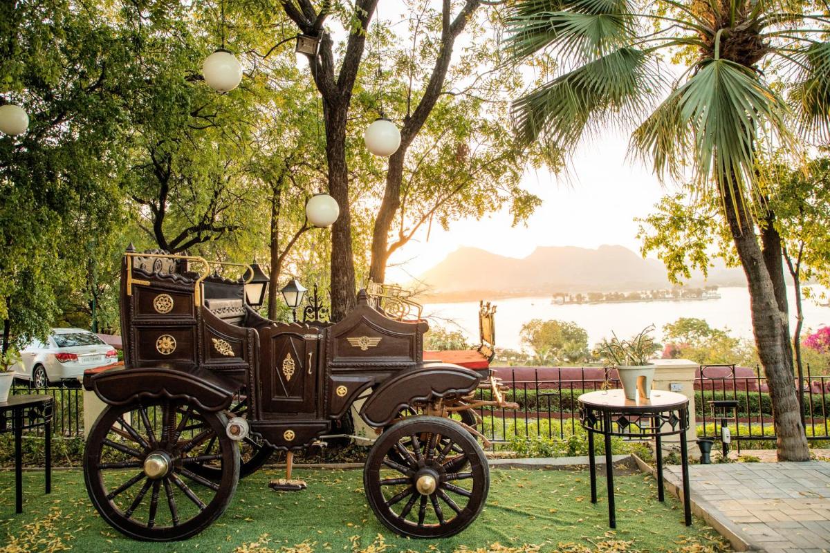 an old car parked next to a table at The Lalit Laxmi Vilas Palace in Udaipur