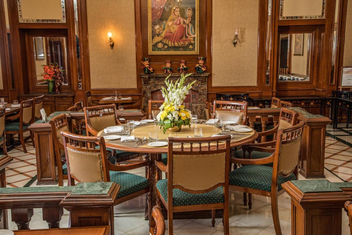 a dining room with a table and chairs at The Lalit Laxmi Vilas Palace in Udaipur