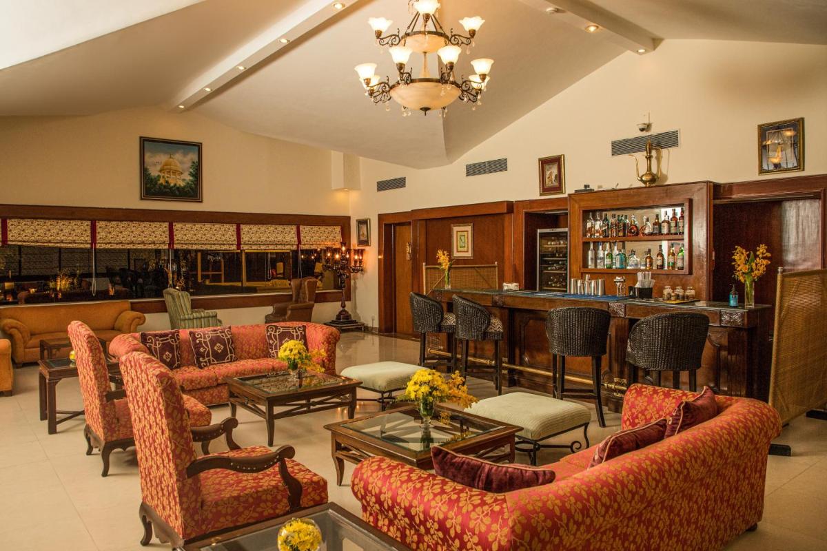 a living room with couches and a bar at The Lalit Laxmi Vilas Palace in Udaipur