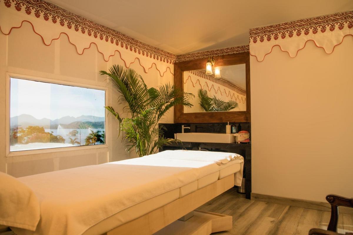 a bedroom with a bed and a window at The Lalit Laxmi Vilas Palace in Udaipur