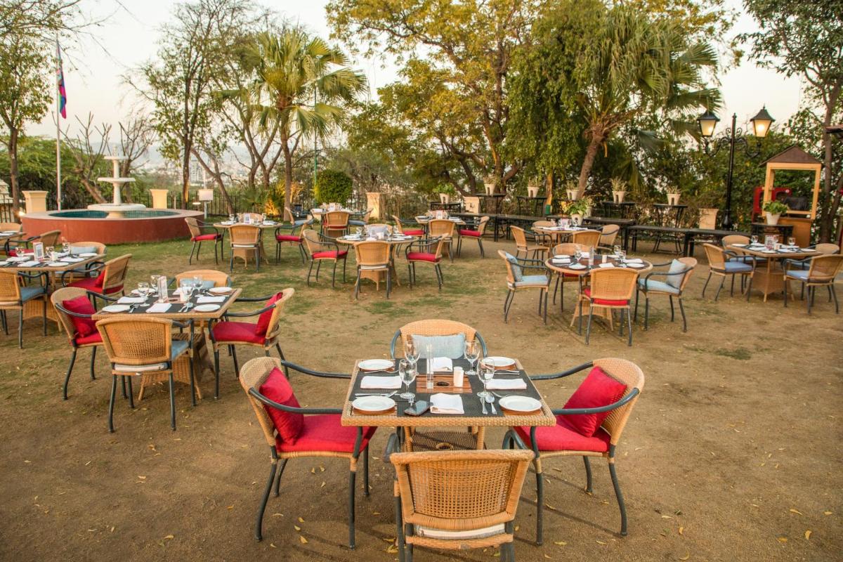 a group of tables and chairs in a yard at The Lalit Laxmi Vilas Palace in Udaipur