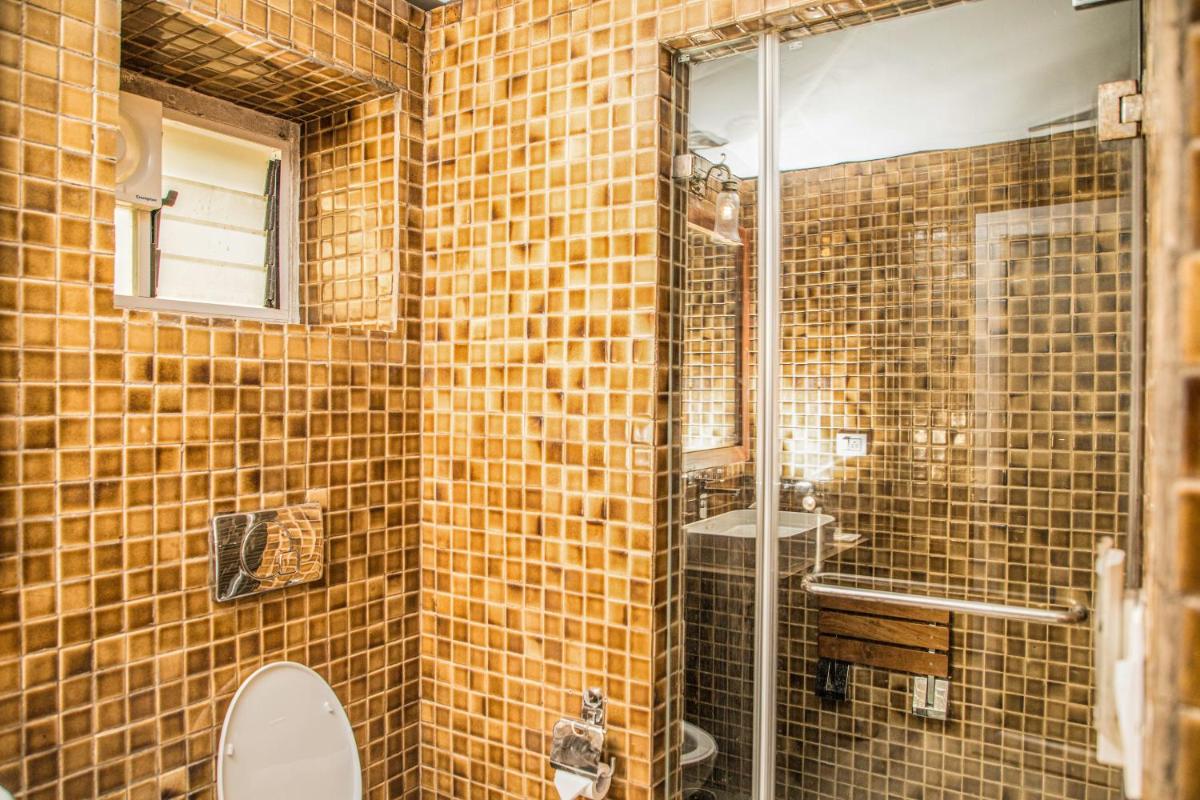 a bathroom with a shower and a toilet and a sink at The Lalit Laxmi Vilas Palace in Udaipur