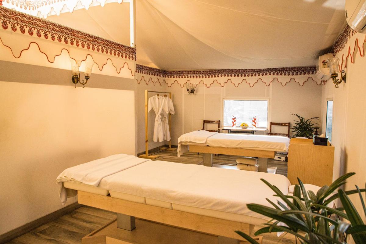 a room with two beds in a room with a tent at The Lalit Laxmi Vilas Palace in Udaipur